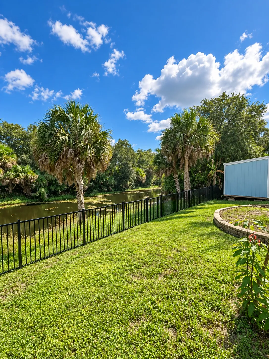 Fenced backyard with palm trees on a canal in Port Charlotte