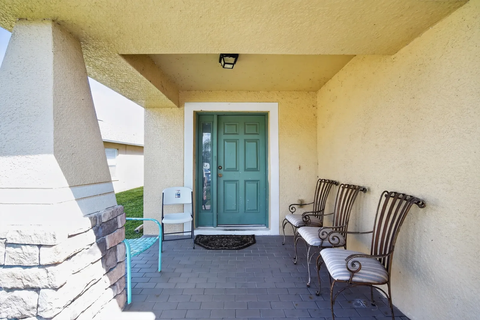 Covered front porch with seating at a Wesley Chapel home